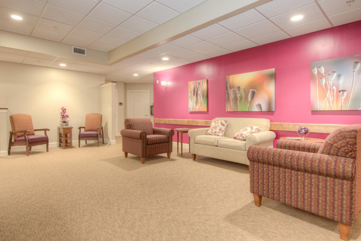 A cozy lounge area with comfortable seating and vibrant pink walls.