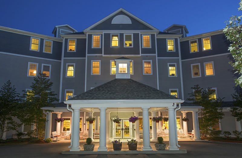 A brightly lit hotel entrance at night with a welcoming facade.