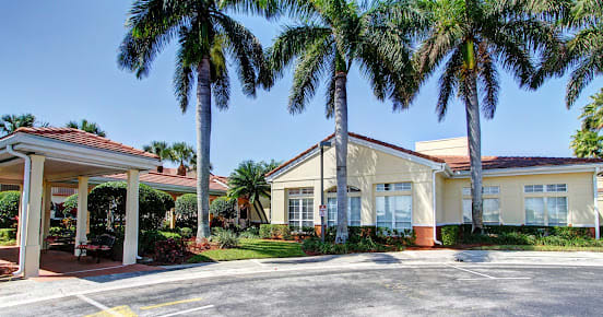 A tropical building surrounded by palm trees under a clear blue sky.