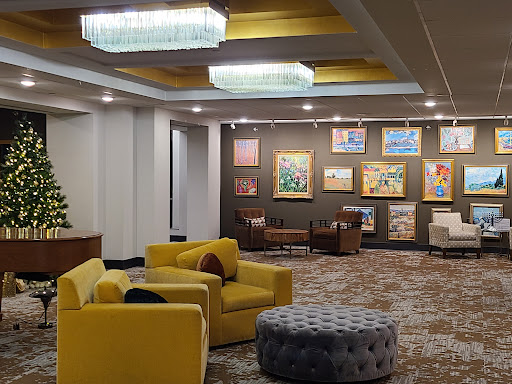 A cozy lounge area featuring modern yellow seating, artistic wall decor, and elegant lighting.