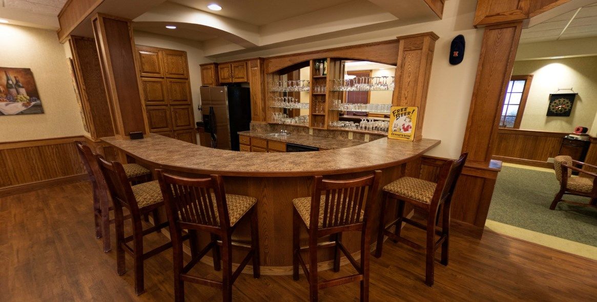A cozy home bar with wooden furniture and a well-organized countertop.