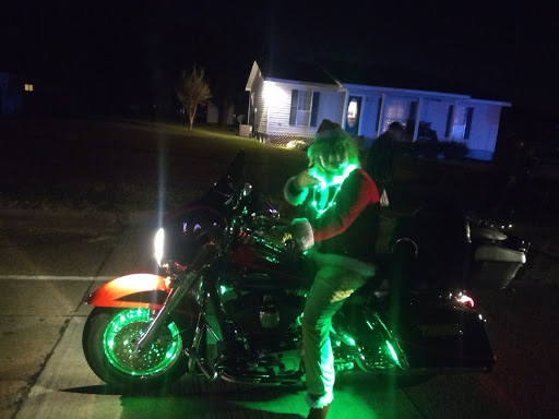 A festive rider on a motorcycle adorned with glowing green lights, celebrating the holiday spirit.
