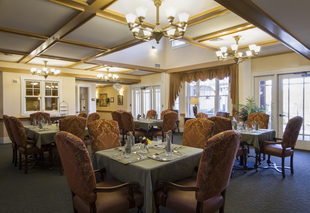 A beautifully decorated dining room with elegant chandeliers and neatly arranged tables.