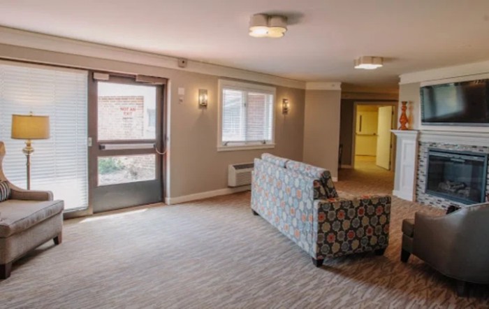 A spacious lobby area featuring a patterned sofa, carpet flooring, and ample lighting.