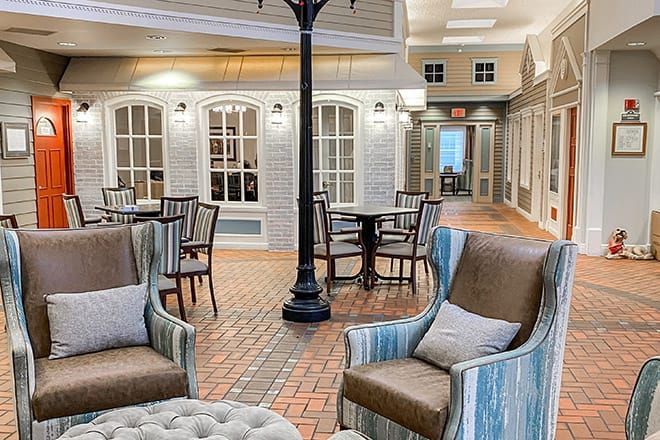 A cozy indoor seating area with comfortable chairs and tables, styled like a street scene.