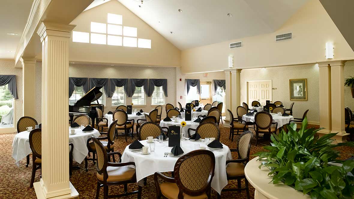 A beautifully arranged dining area with elegant tables and a piano.