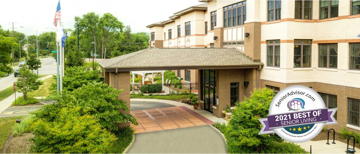 A well-maintained building entrance surrounded by lush greenery and landscaped pathways.