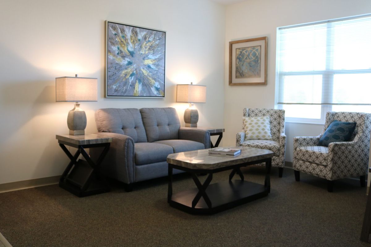 A cozy living room with a sofa, coffee table, and decorative artworks on the walls.