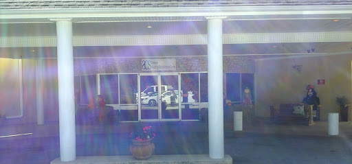 A storefront with reflections and a parked vehicle.