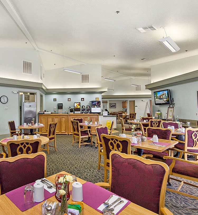 An empty dining area in a restaurant with neatly arranged tables and chairs.