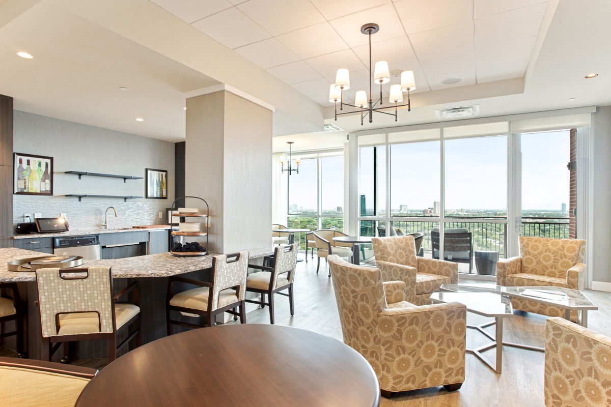 A modern and bright seating area with large windows and stylish furniture.
