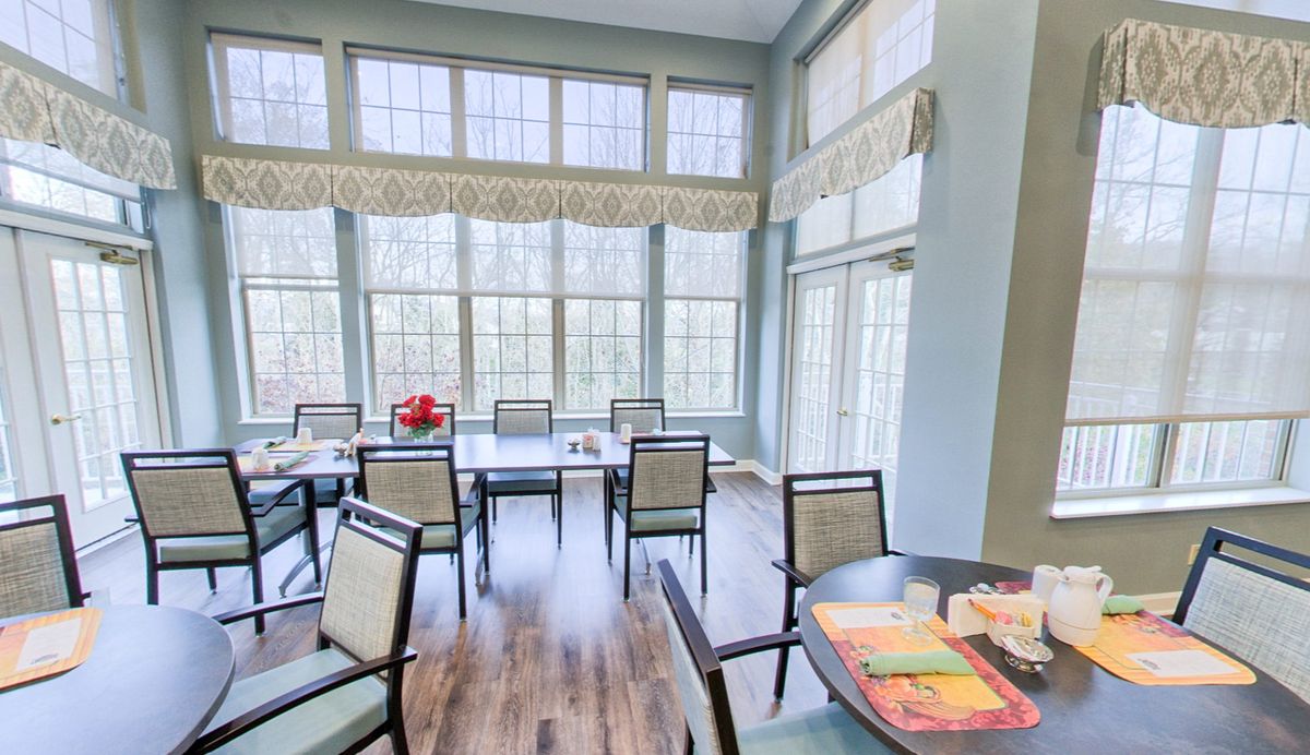 A modern dining room with large windows and ample natural light.