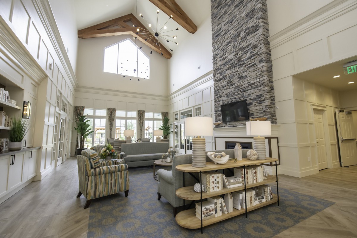Spacious modern living room with high ceilings and a stone fireplace.