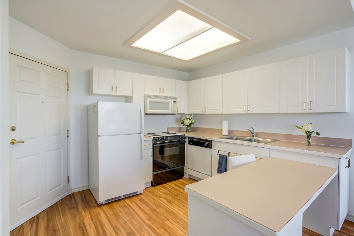 Modern kitchen with white cabinets and appliances.
