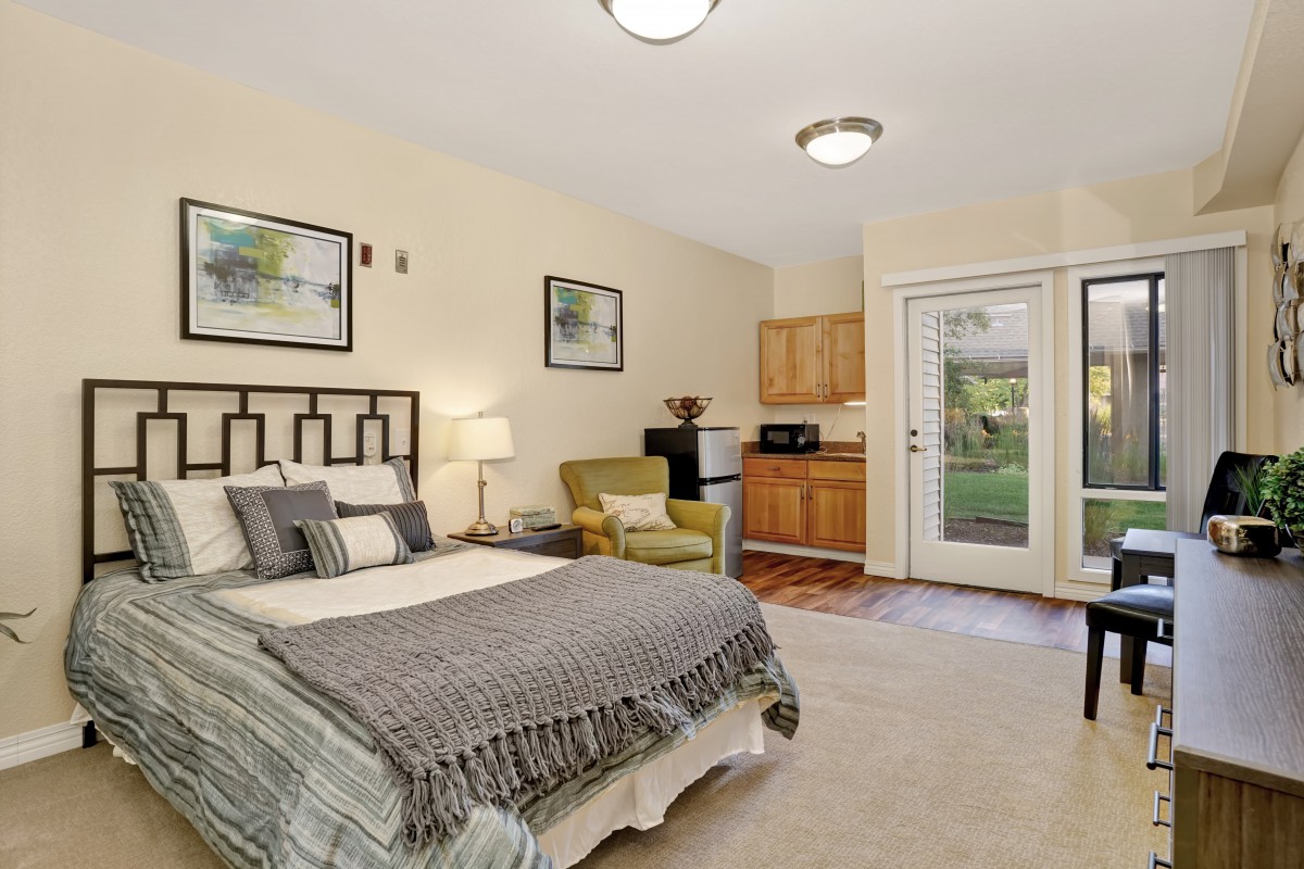 A cozy bedroom with a kitchenette and comfortable furnishings.