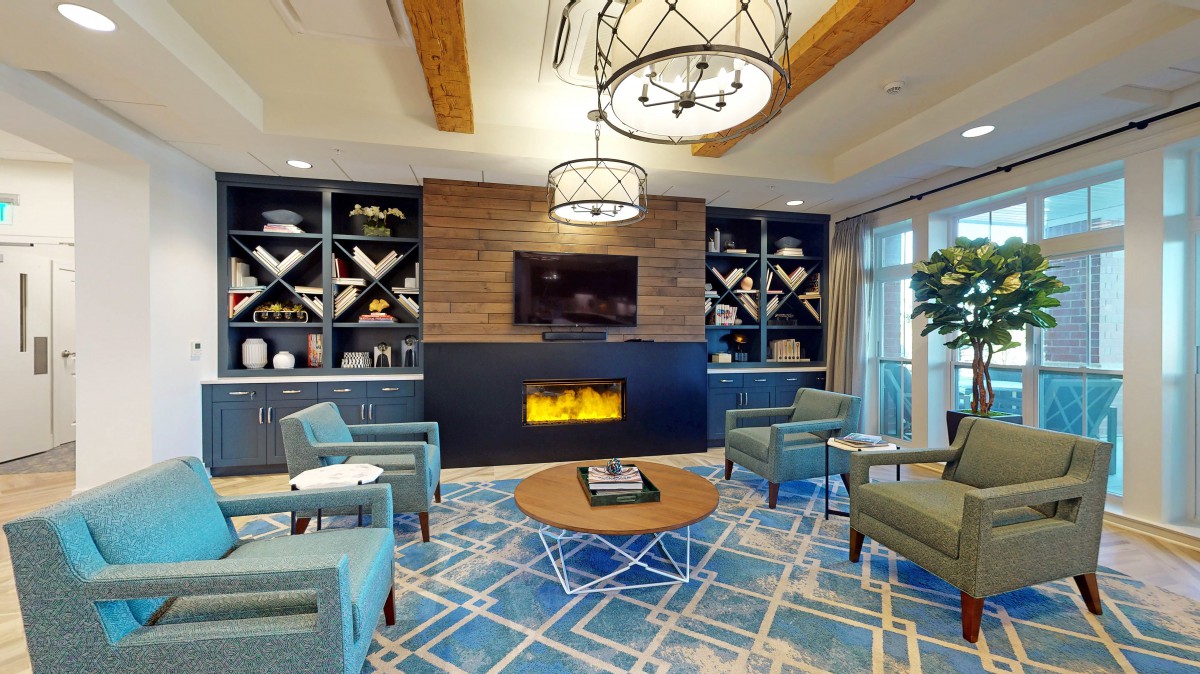 A modern living room with a cozy fireplace, stylish seating, and decorative shelves.