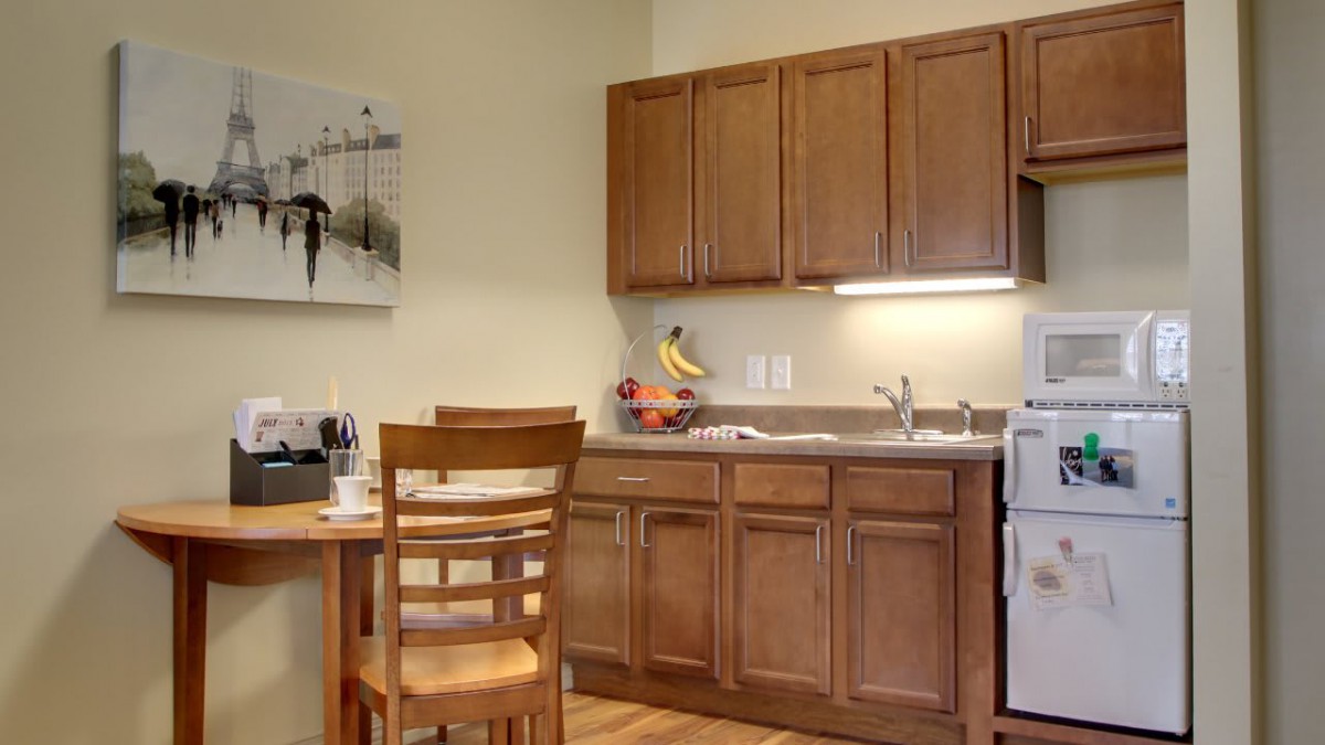A cozy kitchen with wooden cabinets and a small dining area.
