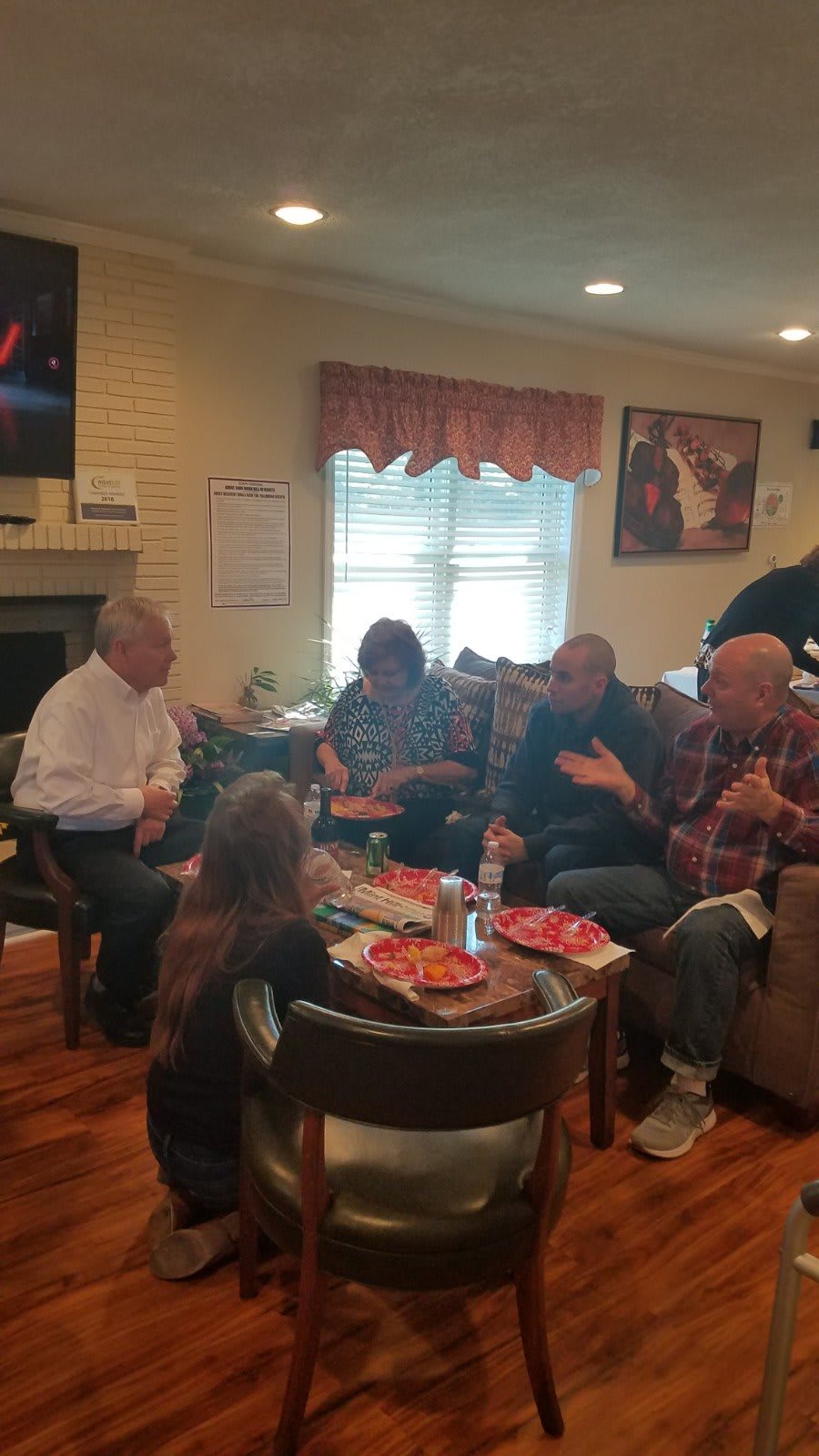 A group of people enjoying a family gathering in a cozy living room setting.