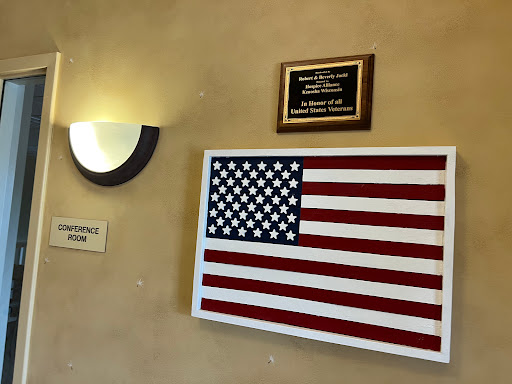 An American flag displayed on a wall alongside a plaque, representing patriotism and national pride.