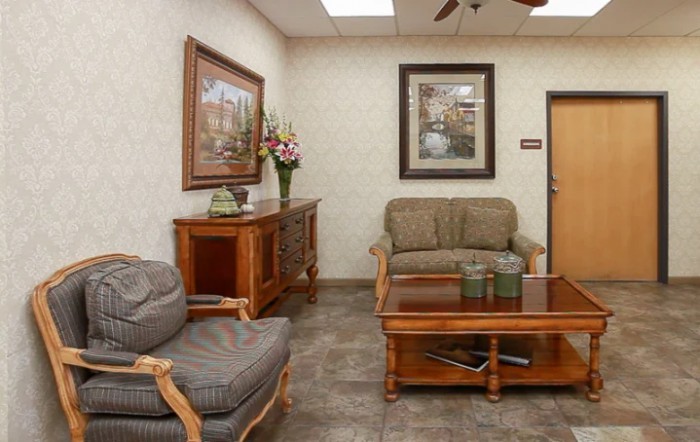 A cozy waiting room with comfortable seating and decorative artwork on the walls.