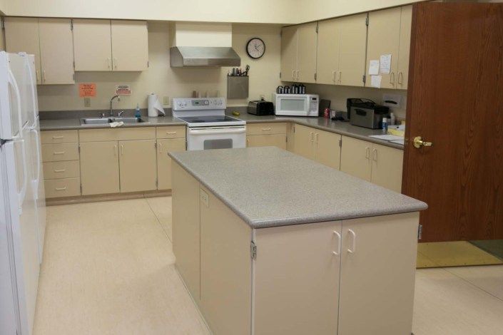 A spacious kitchen with beige cabinets and a central island.