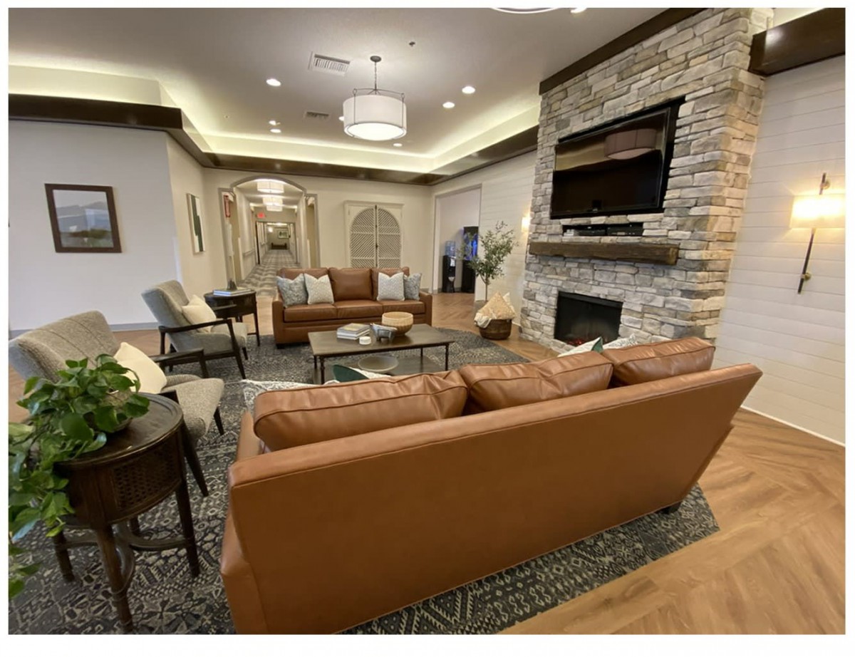 A modern living room featuring comfortable sofas, a stone fireplace, and elegant lighting.