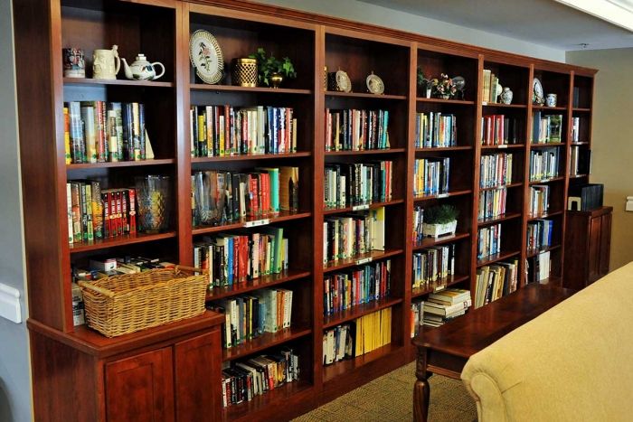 A cozy reading room with wooden bookshelves filled with a variety of books.