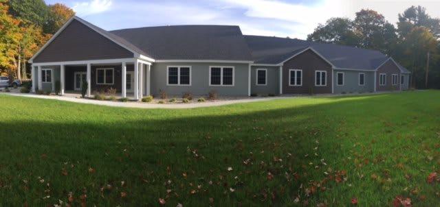 A single-story suburban house with a spacious lawn and a modern design.