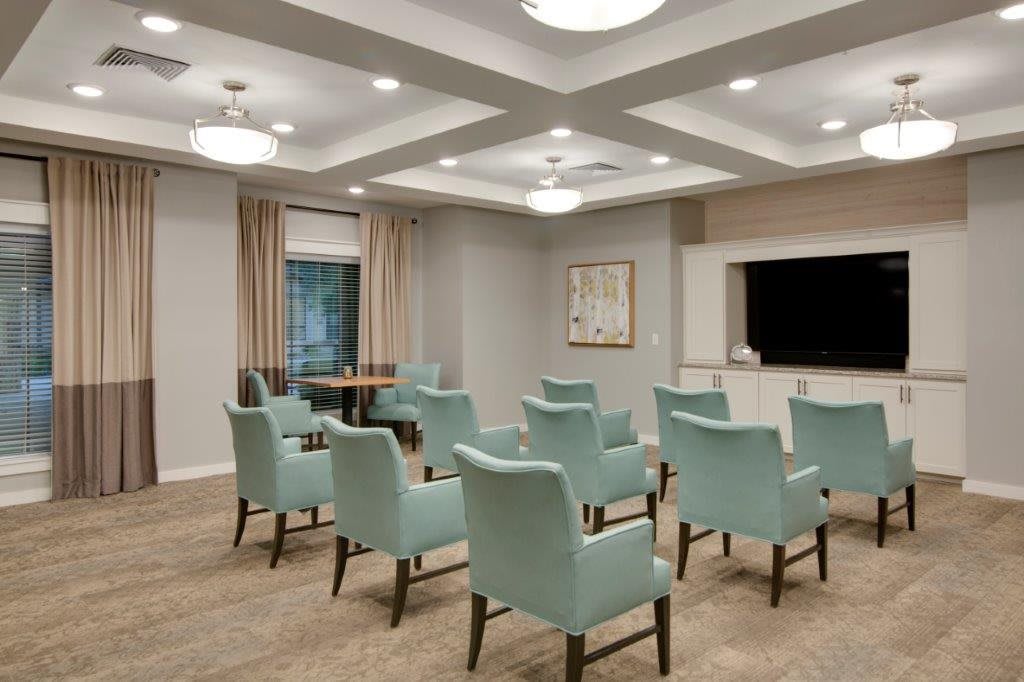 A modern conference room with neatly arranged chairs and contemporary lighting.