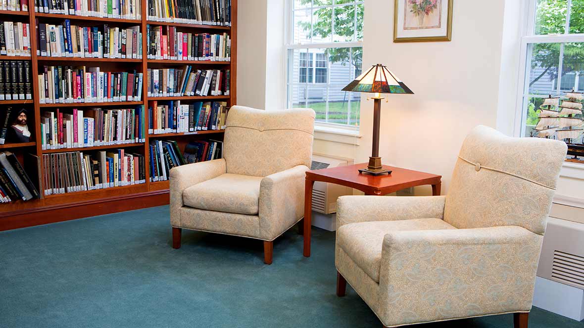 Cozy reading nook with armchairs and bookshelves.