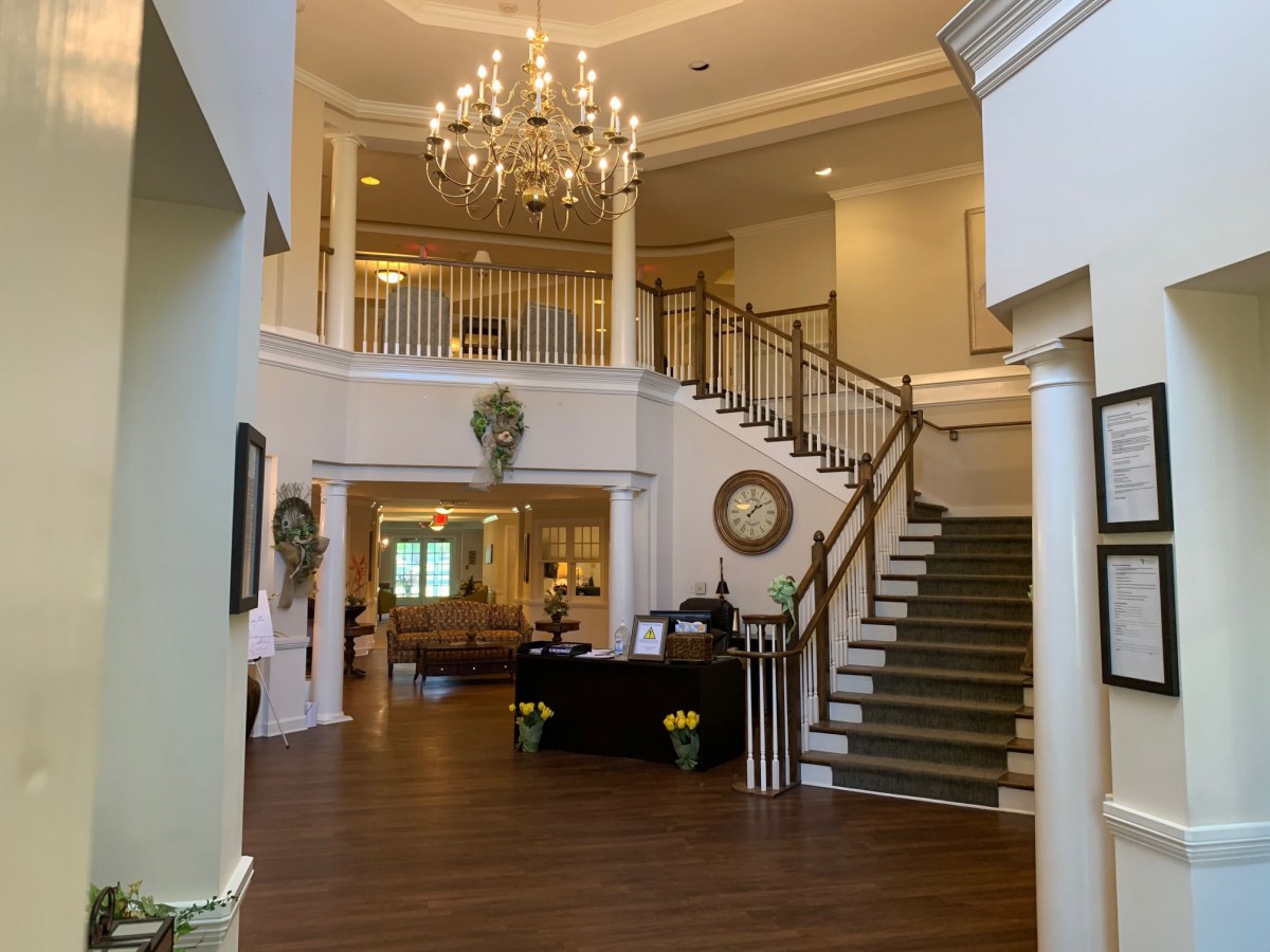 A luxurious foyer with a grand staircase and elegant chandelier.