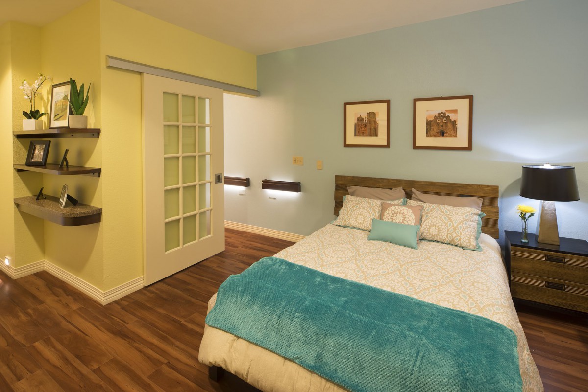 A cozy bedroom featuring modern decor, a sliding door, and blue accent colors.