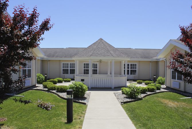 A single-story suburban house with well-maintained lawns and shrubs.