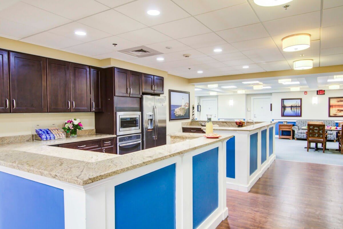 A modern kitchen interior featuring blue and white countertops with dark wooden cabinets and stainless steel appliances.
