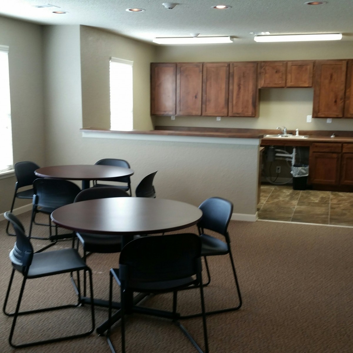 A modern kitchen and dining area with tables and chairs.