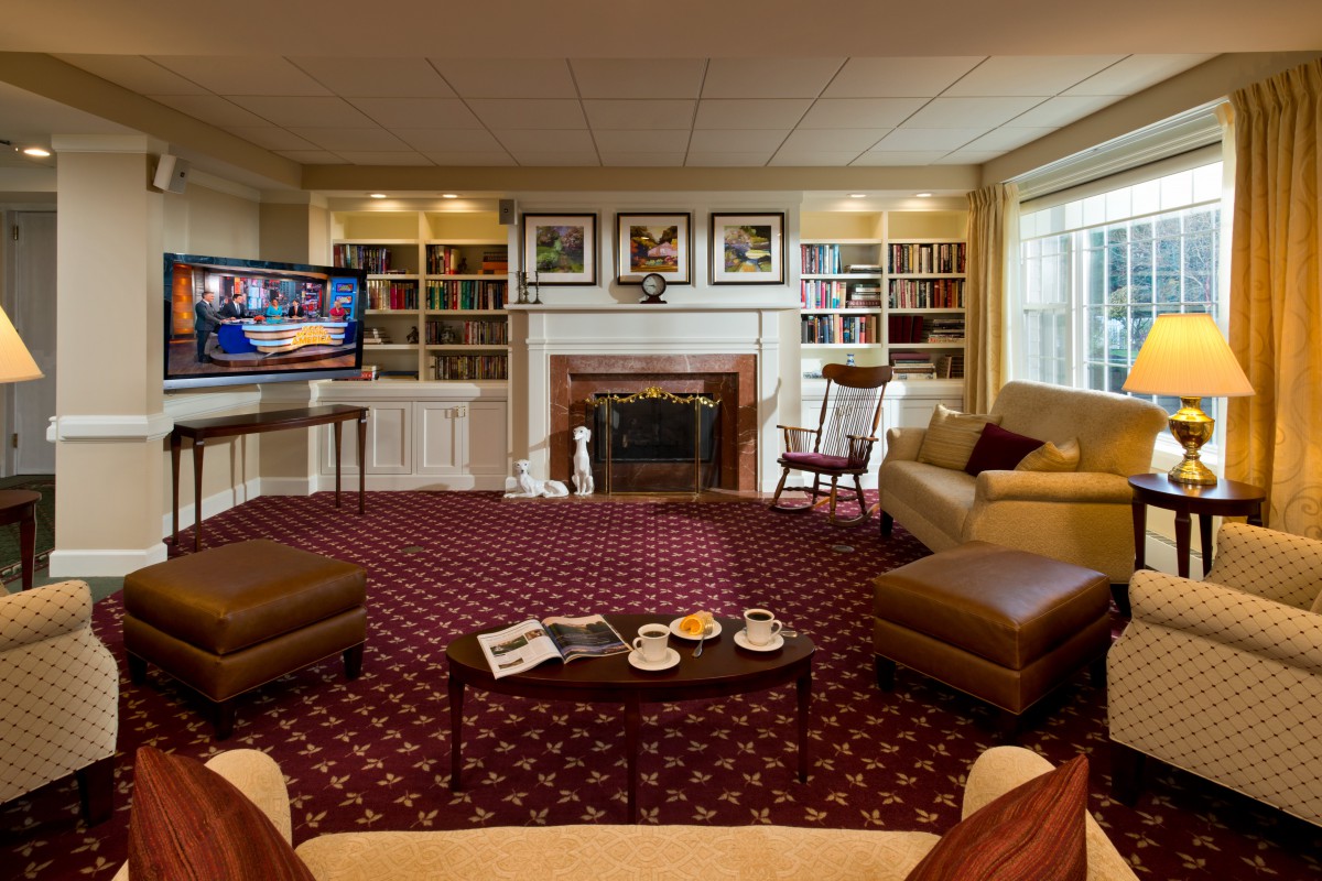 A cozy living room with a fireplace, bookshelves, and comfortable seating.