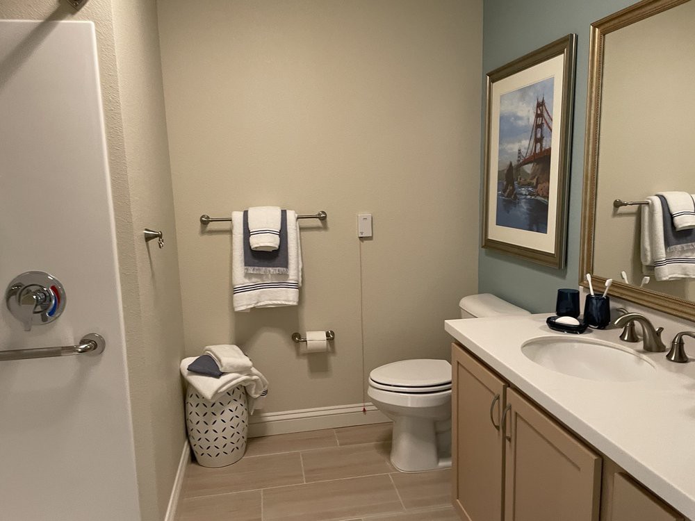 A neatly organized bathroom with towels, a toilet, and a sink.
