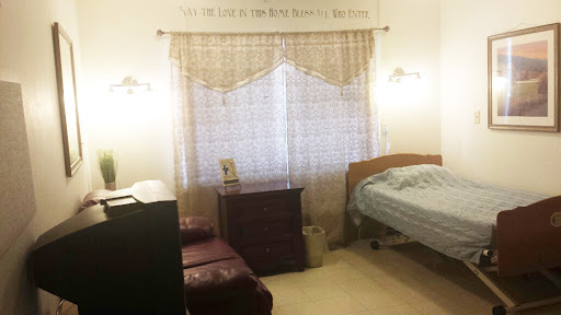 A cozy bedroom featuring soft curtains, a comfortable bed, and warm lighting.