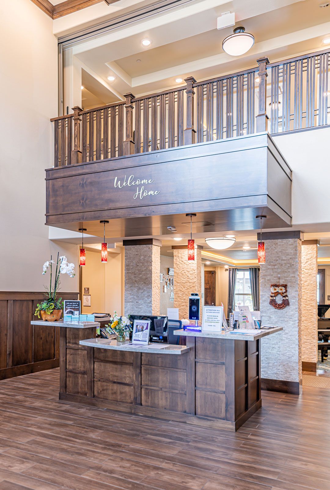 A hotel lobby with a reception desk and wooden decor.