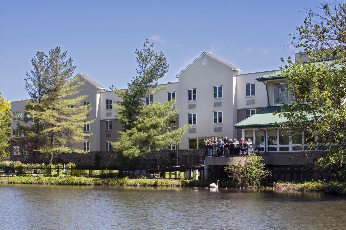 A serene lakeside building surrounded by trees.