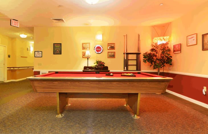 A cozy game room featuring a pool table and wall decorations.