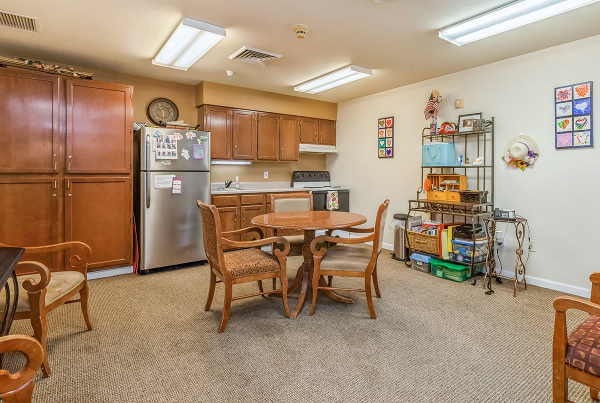 A cozy kitchen and dining area with a wooden table, four chairs, and modern appliances.