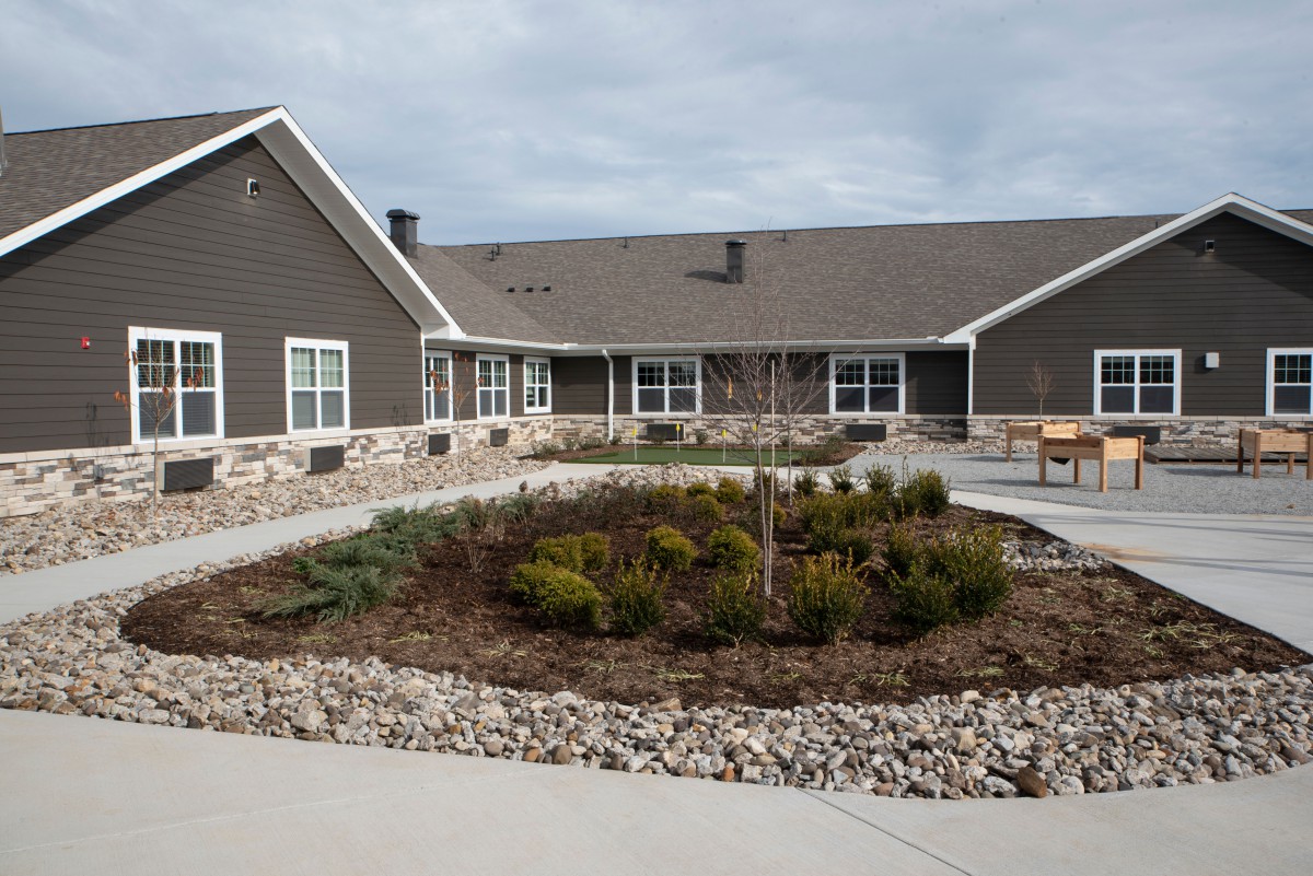 A view of a residential building with a well-maintained garden in front.