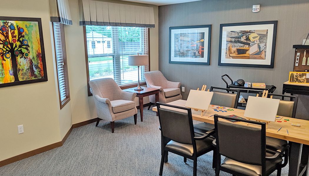 A modern office meeting room with comfortable seating and framed artwork.