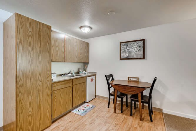 A cozy kitchen with wooden cabinets and a dining area featuring a small table and chairs.