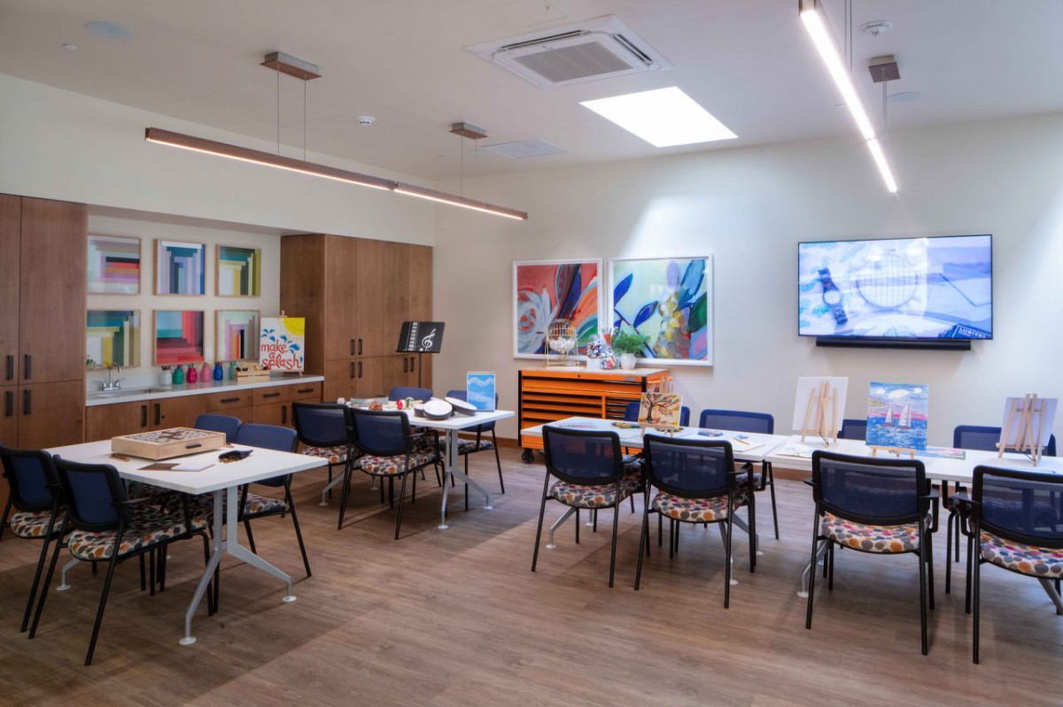 A spacious art studio with tables, chairs, and various art supplies.