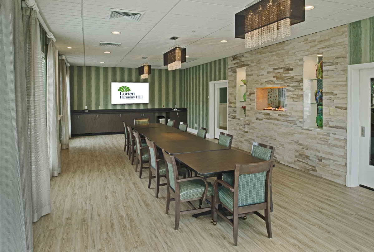 A modern conference room featuring a long meeting table with chairs, striped wallpaper, and a stone accent wall.
