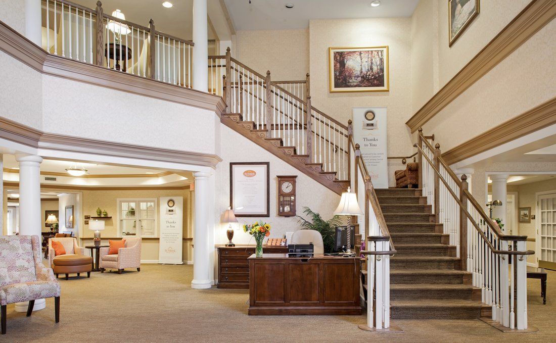 A well-lit reception area featuring a grand staircase and classic decor.