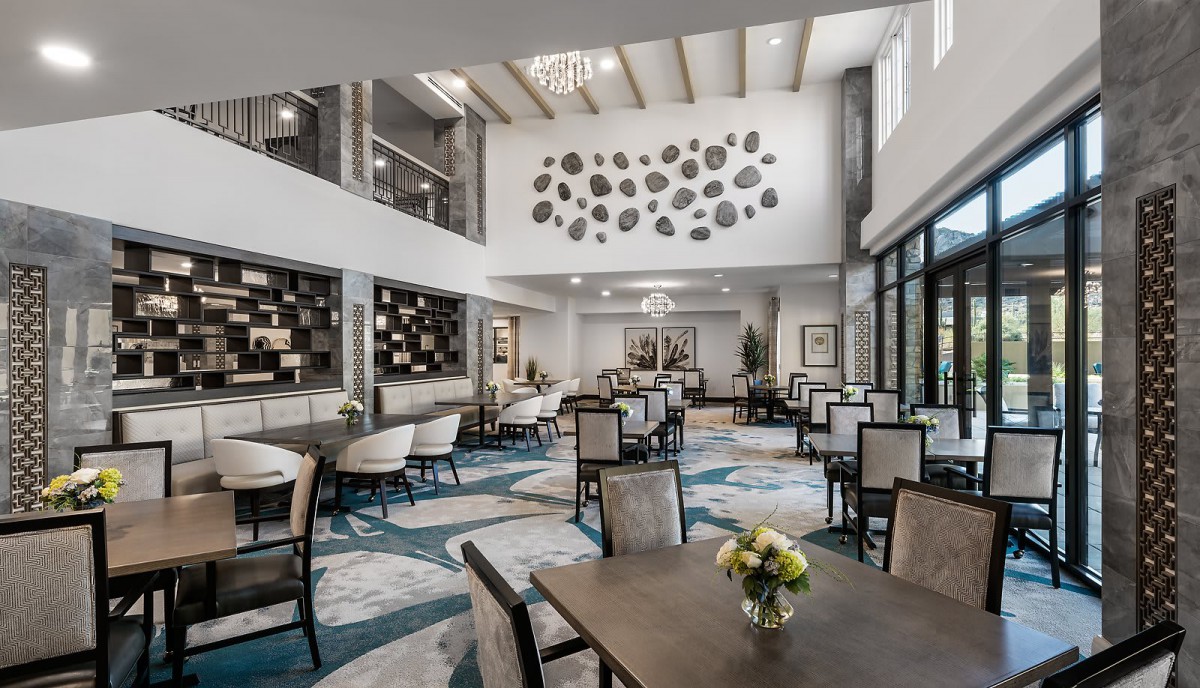 A modern dining area with elegant furniture, high ceilings, and contemporary artwork.