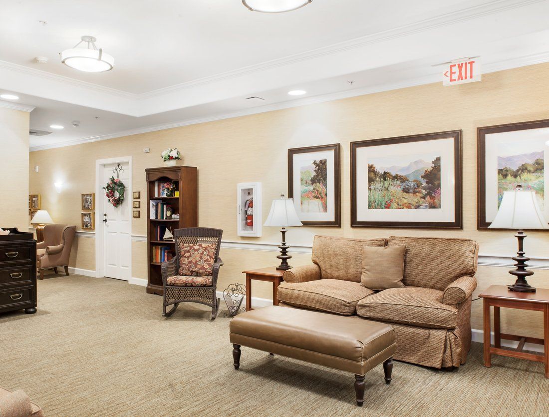 A cozy living room featuring a comfortable sofa, a bookshelf with decor items, and framed artwork on the walls.
